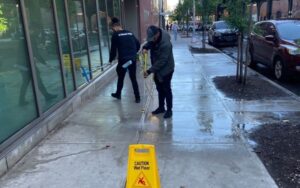 Power washing office building sidewalk